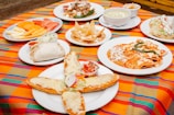 A table topped with lots of plates of food
