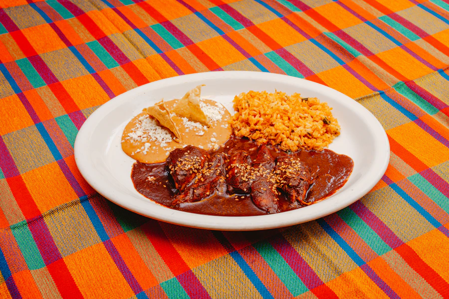 Traditional Mexican mole plate with rice, served on a colorful serape-patterned tablecloth
