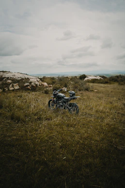 A motorcycle sitting in the middle of a field