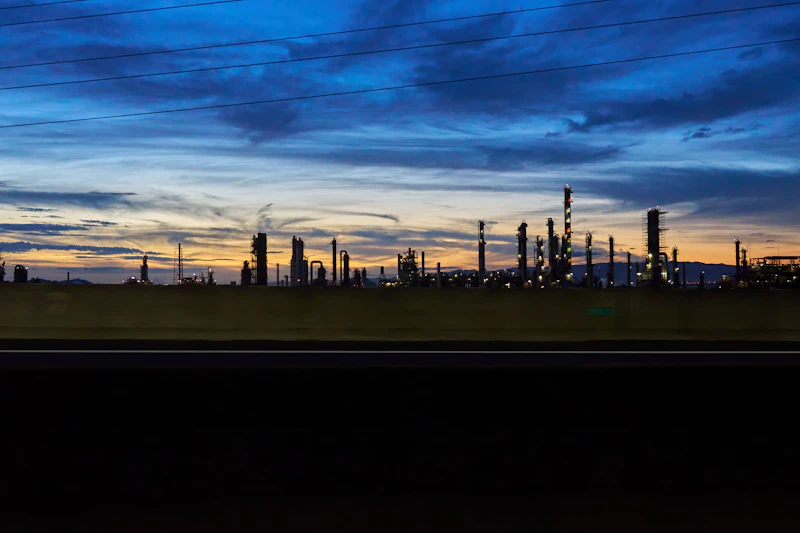 Industrial roadway and refinery towers at dusk