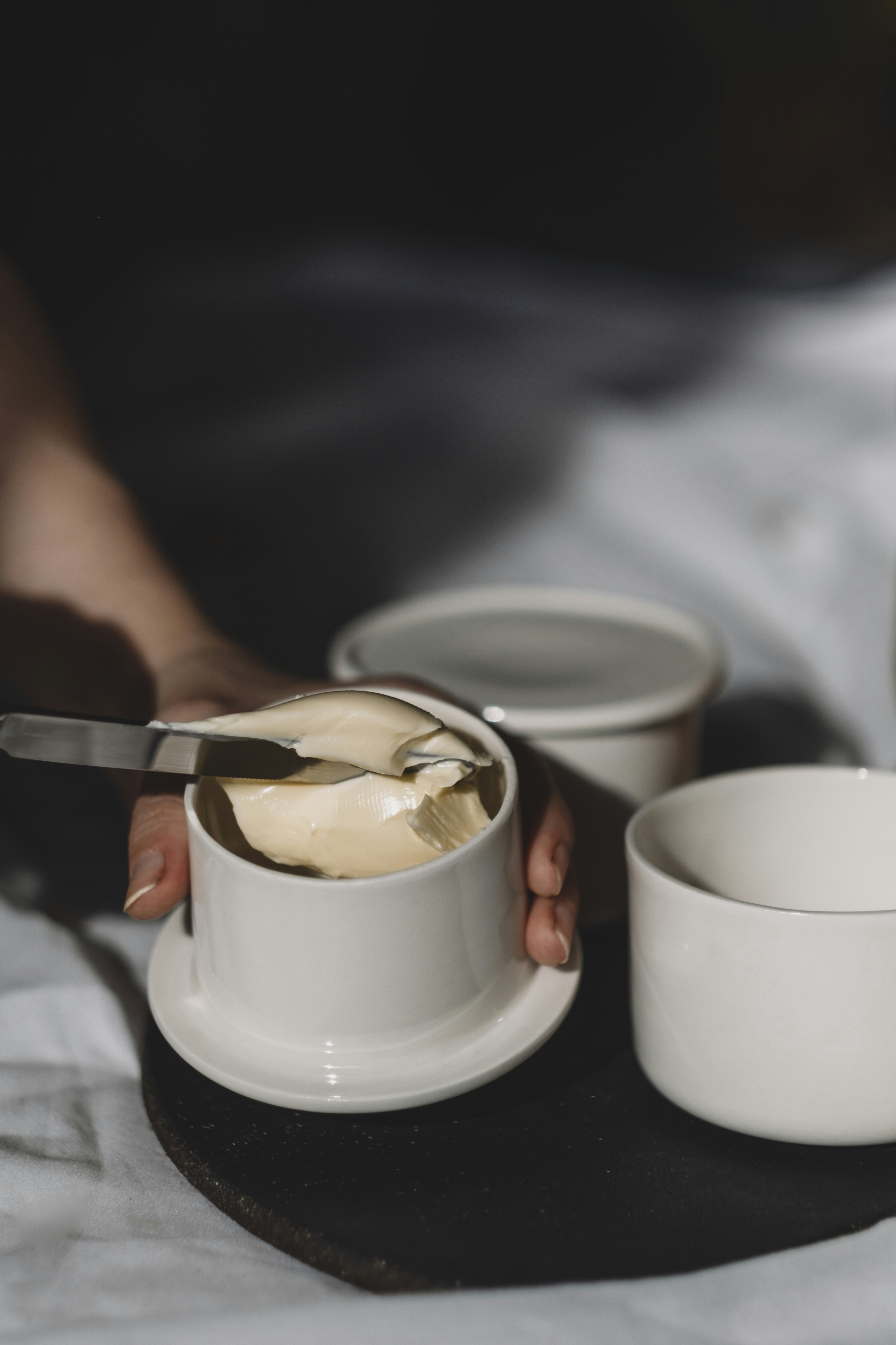 A person is cutting into a cup with a knife