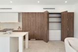 A kitchen with a white counter top next to a white couch