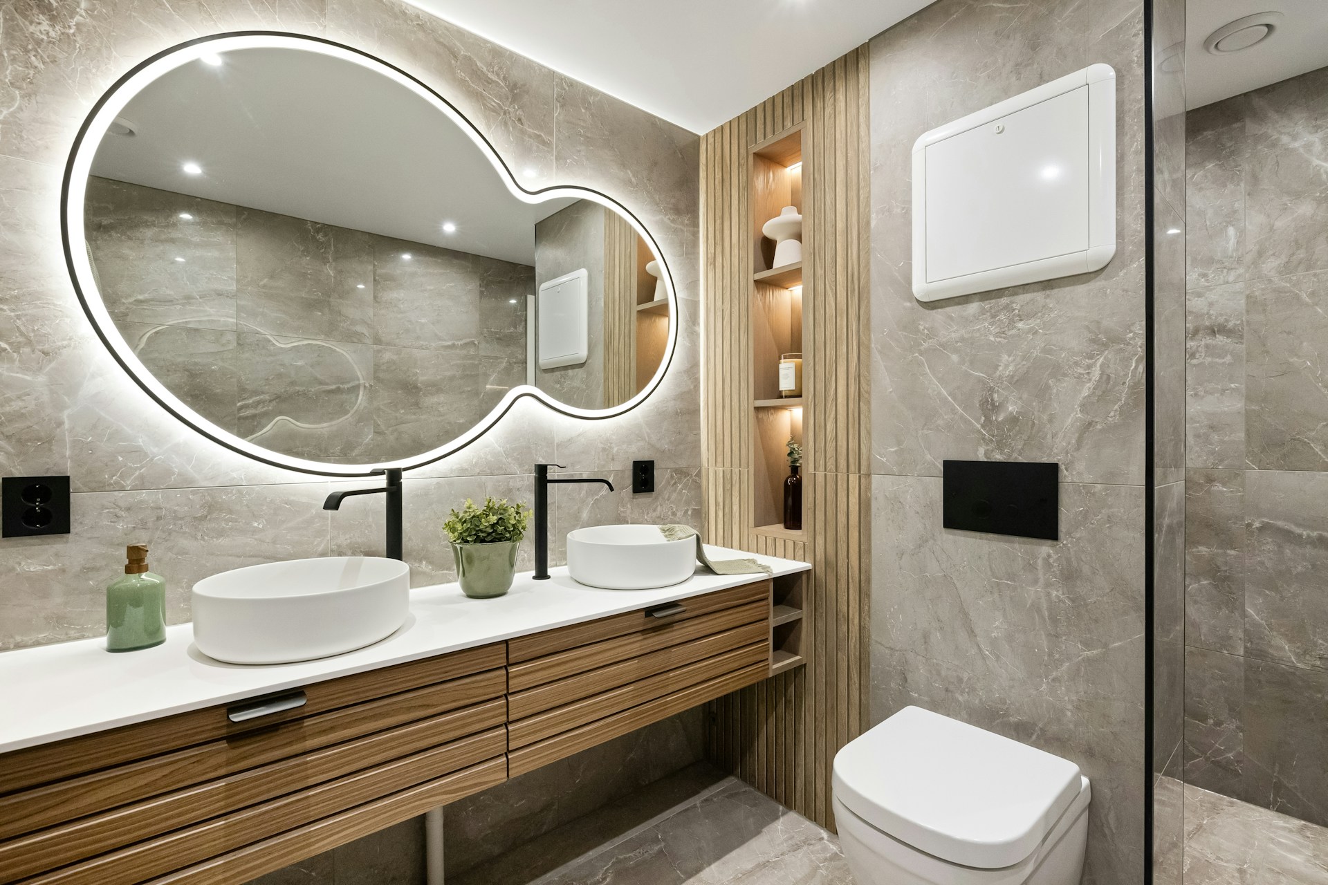 A bathroom with a large round mirror above the sink