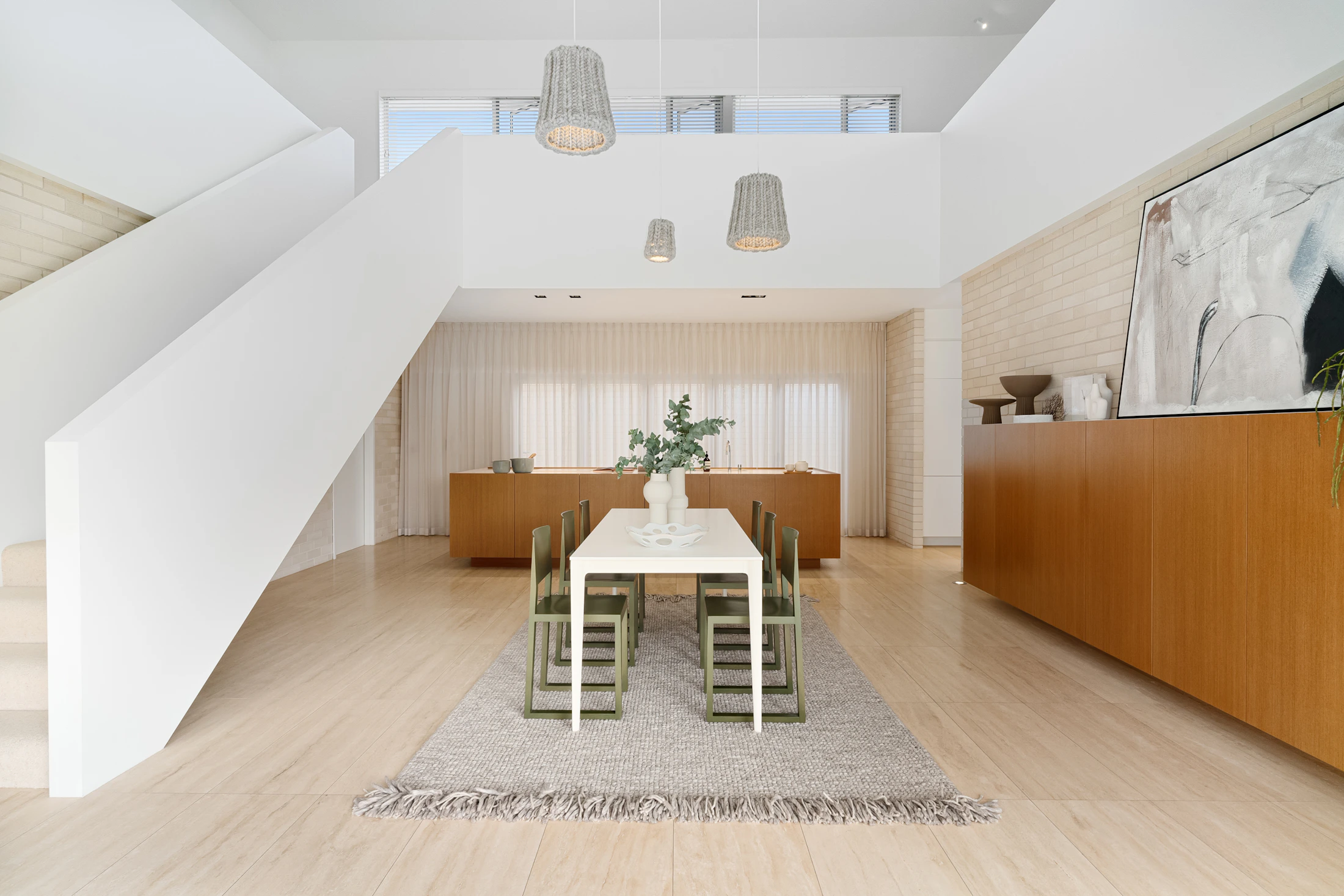 Warm modern dining room with dining table, chairs and refined storage furniture