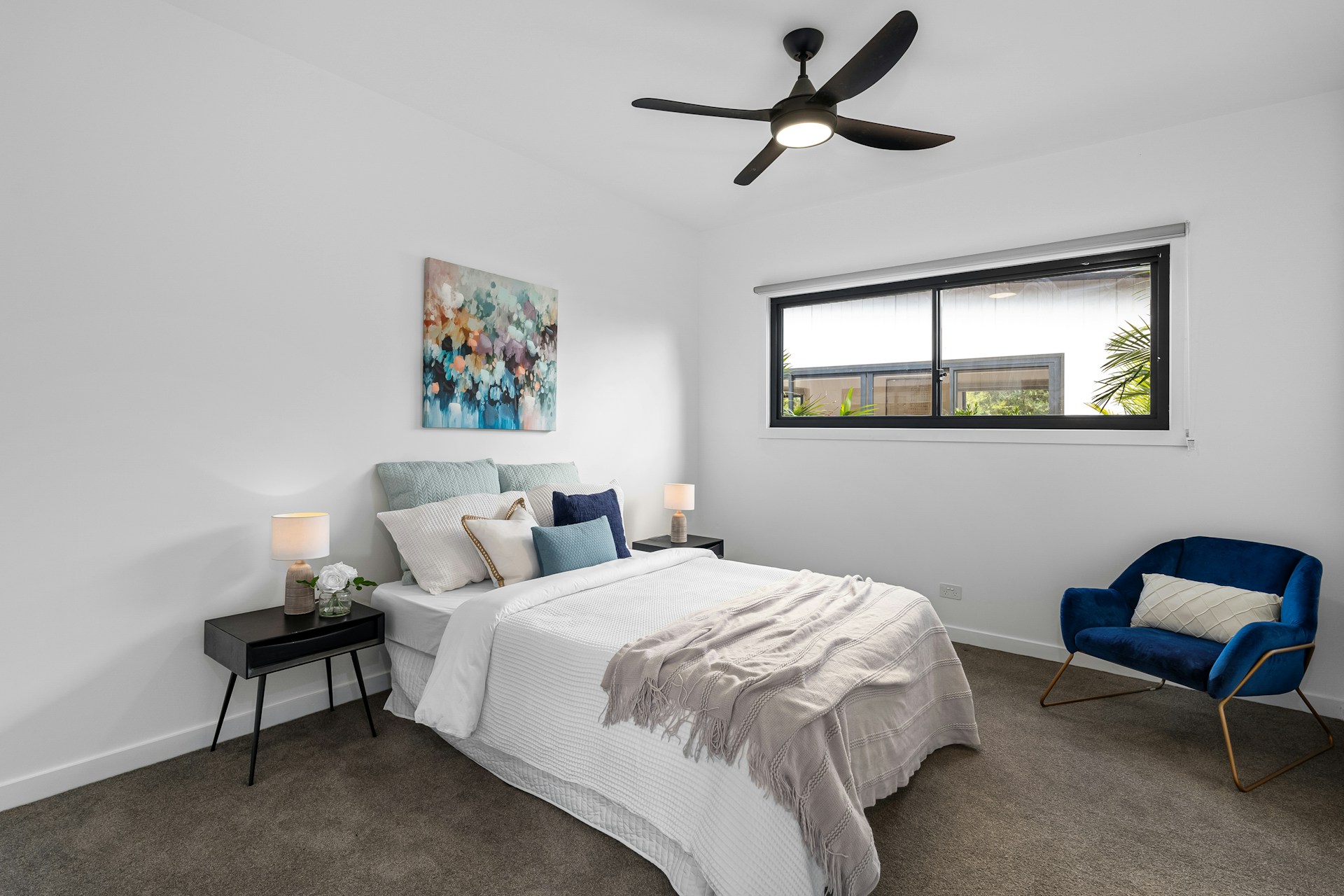 A bedroom with a ceiling fan and a bed