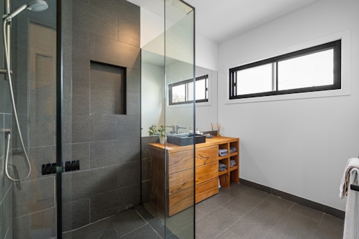 A bathroom with a walk in shower next to a sink