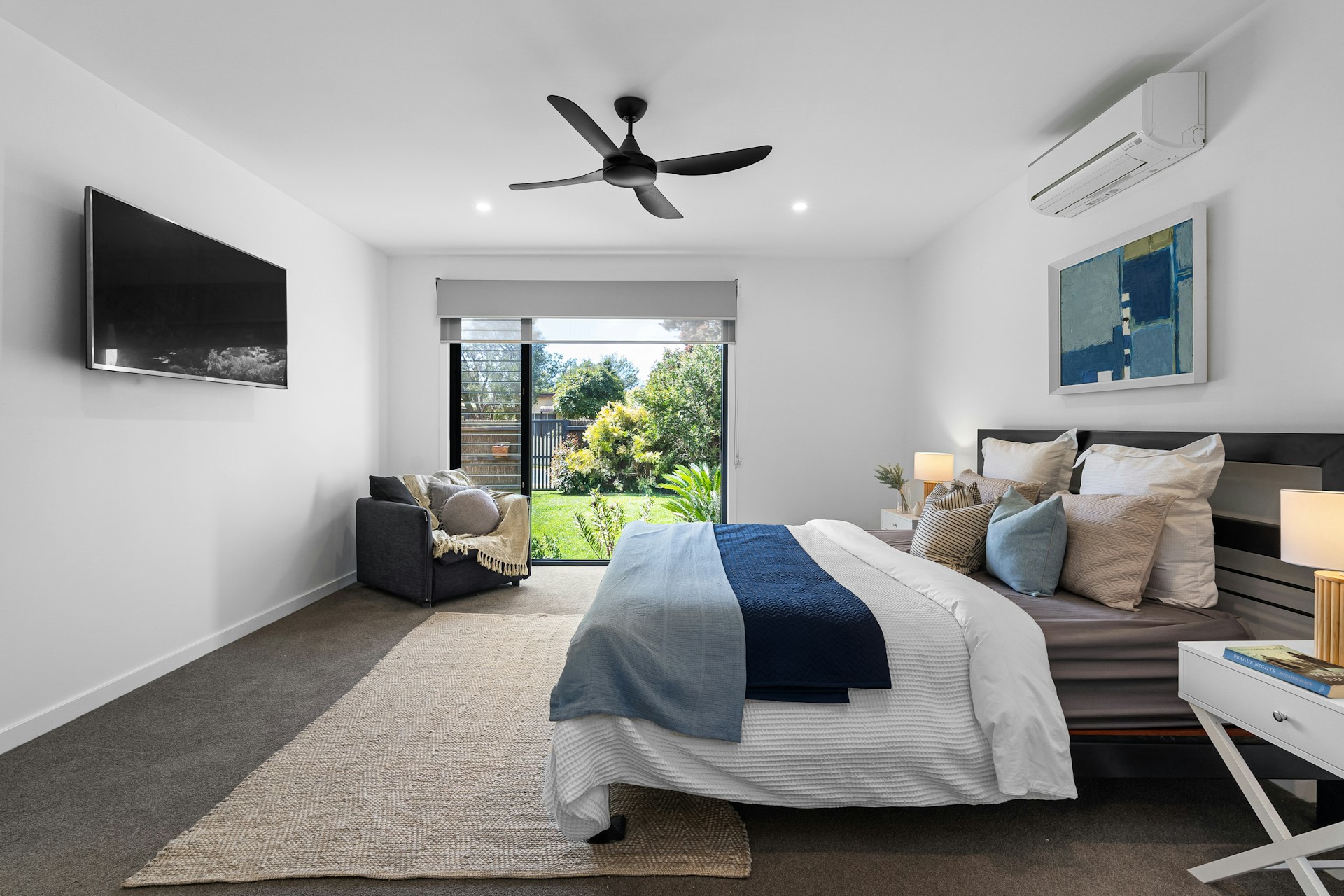 A bed room with a neatly made bed and a flat screen TV
