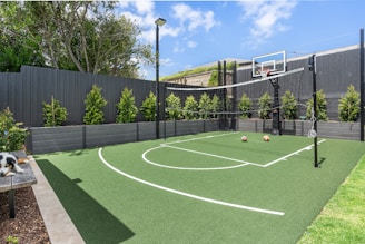 A backyard with a basketball court and basketball hoop