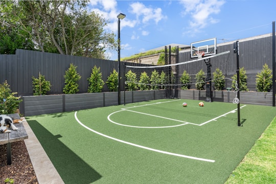 A backyard with a basketball court and basketball hoop