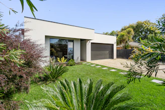A house with a large yard and trees in front of it