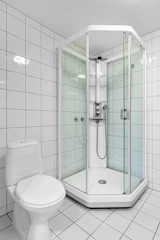 A bathroom with a toilet, shower, and sink