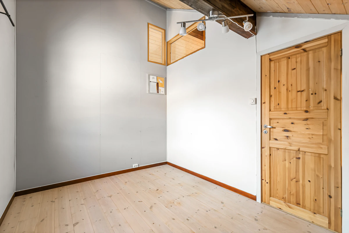 An empty room with wood floors and a wooden door