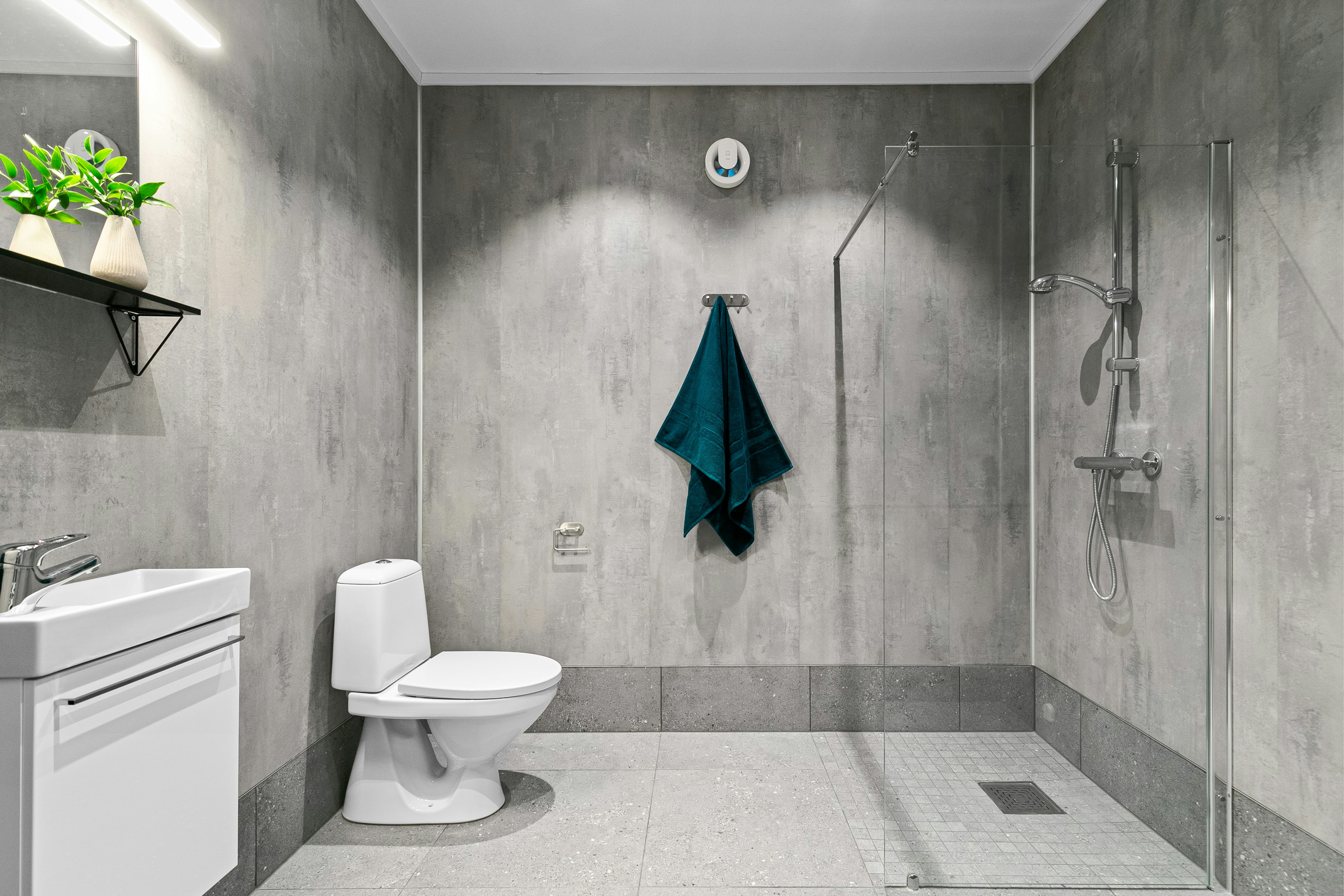 A bathroom with a toilet, sink, and shower