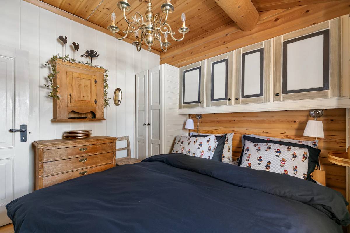 Dormitorio con cabecero de madera y ropa de cama estampada