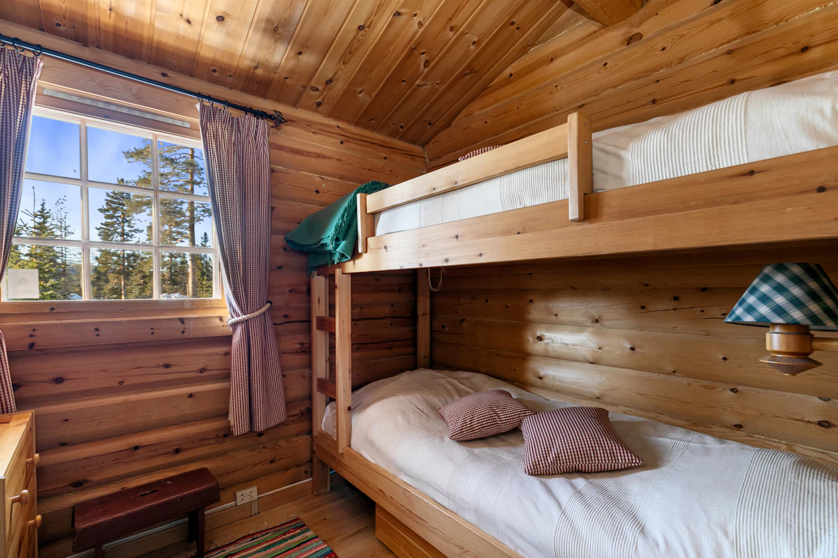 Literas de madera junto a una ventana con vistas a los árboles