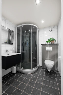 A bathroom with a toilet, shower and sink