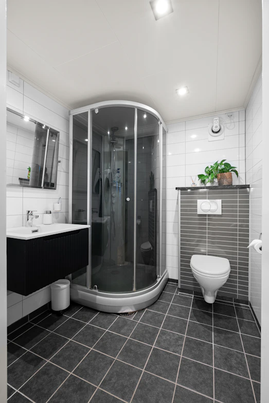 A bathroom with a toilet, shower and sink