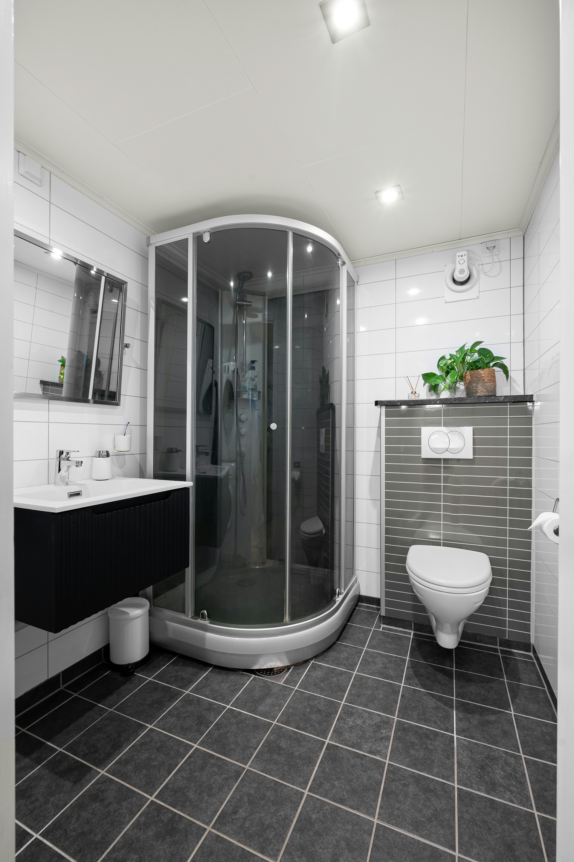 A bathroom with a toilet, shower and sink