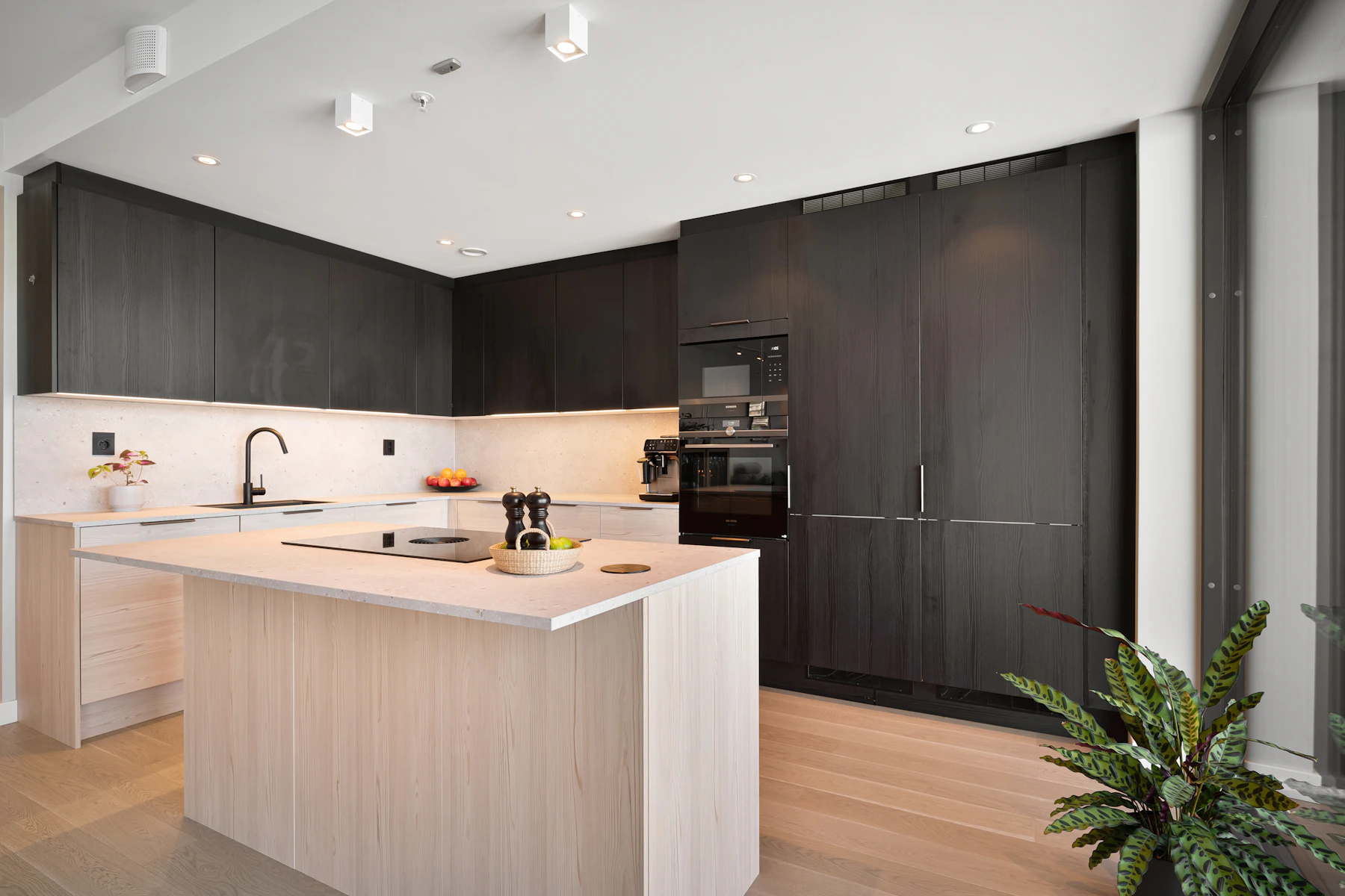 Contemporary kitchen with light timber island and dark cabinetry