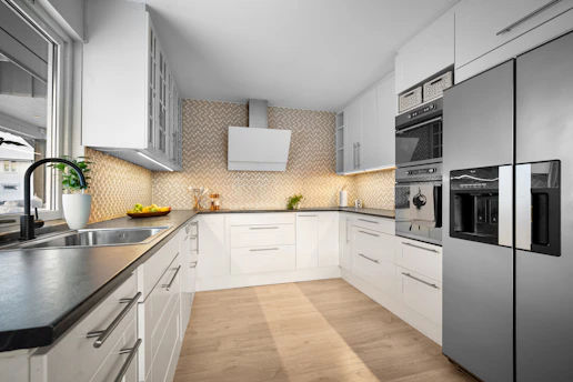 A kitchen with a refrigerator and a sink
