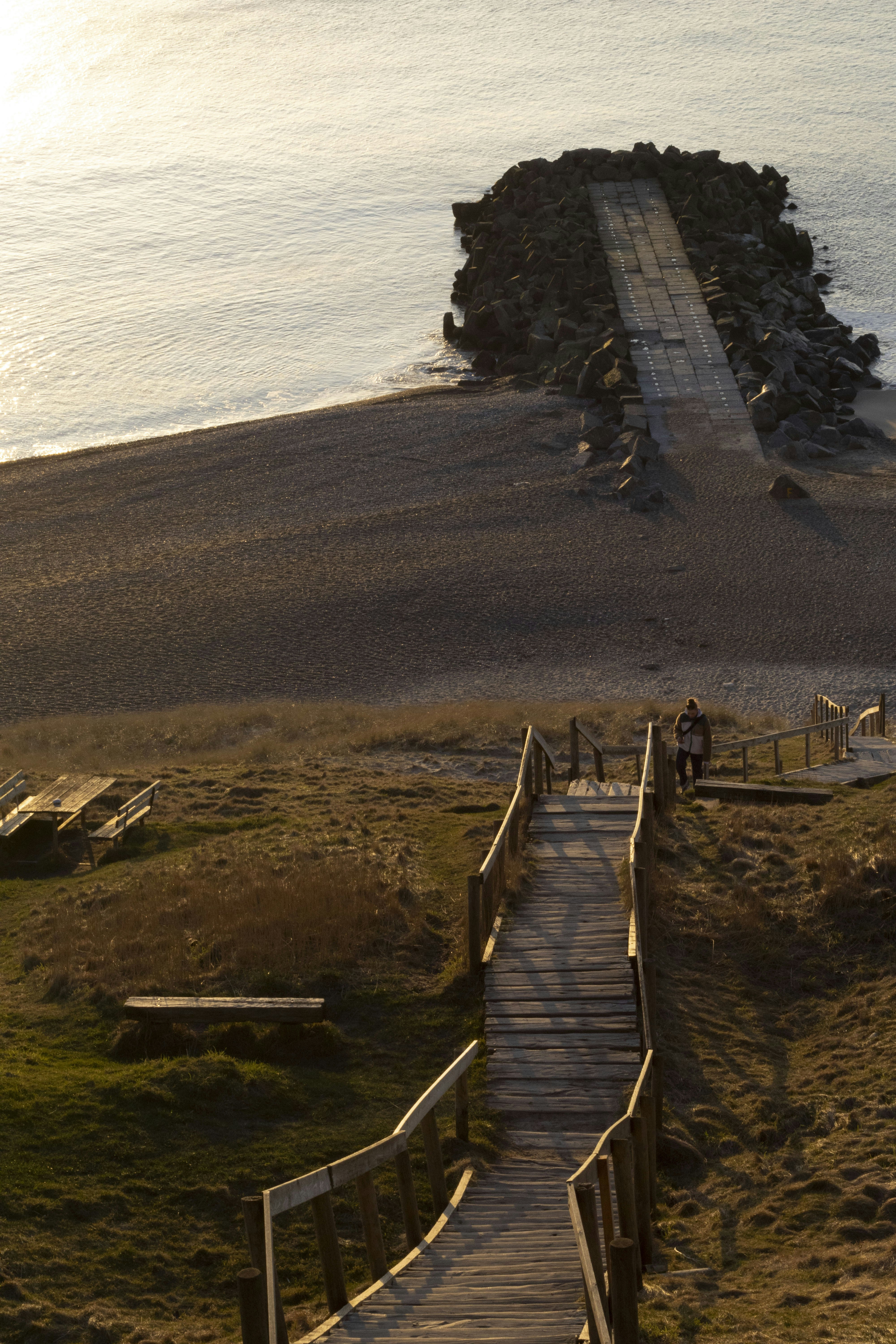 A wooden walkway leading to a sandy beach