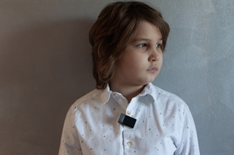 A young boy wearing a white shirt and black tie