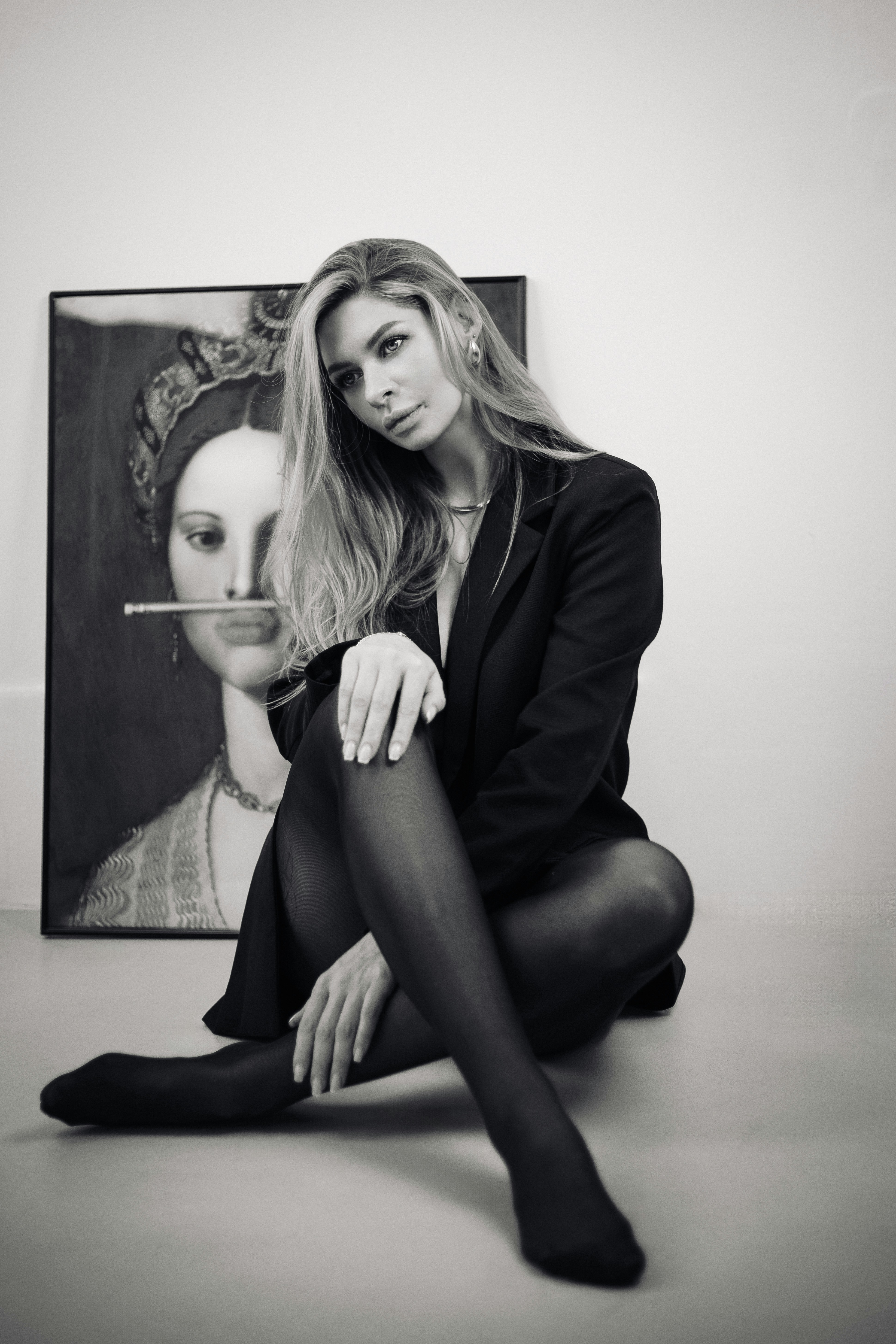 A woman sitting on the floor in front of a painting