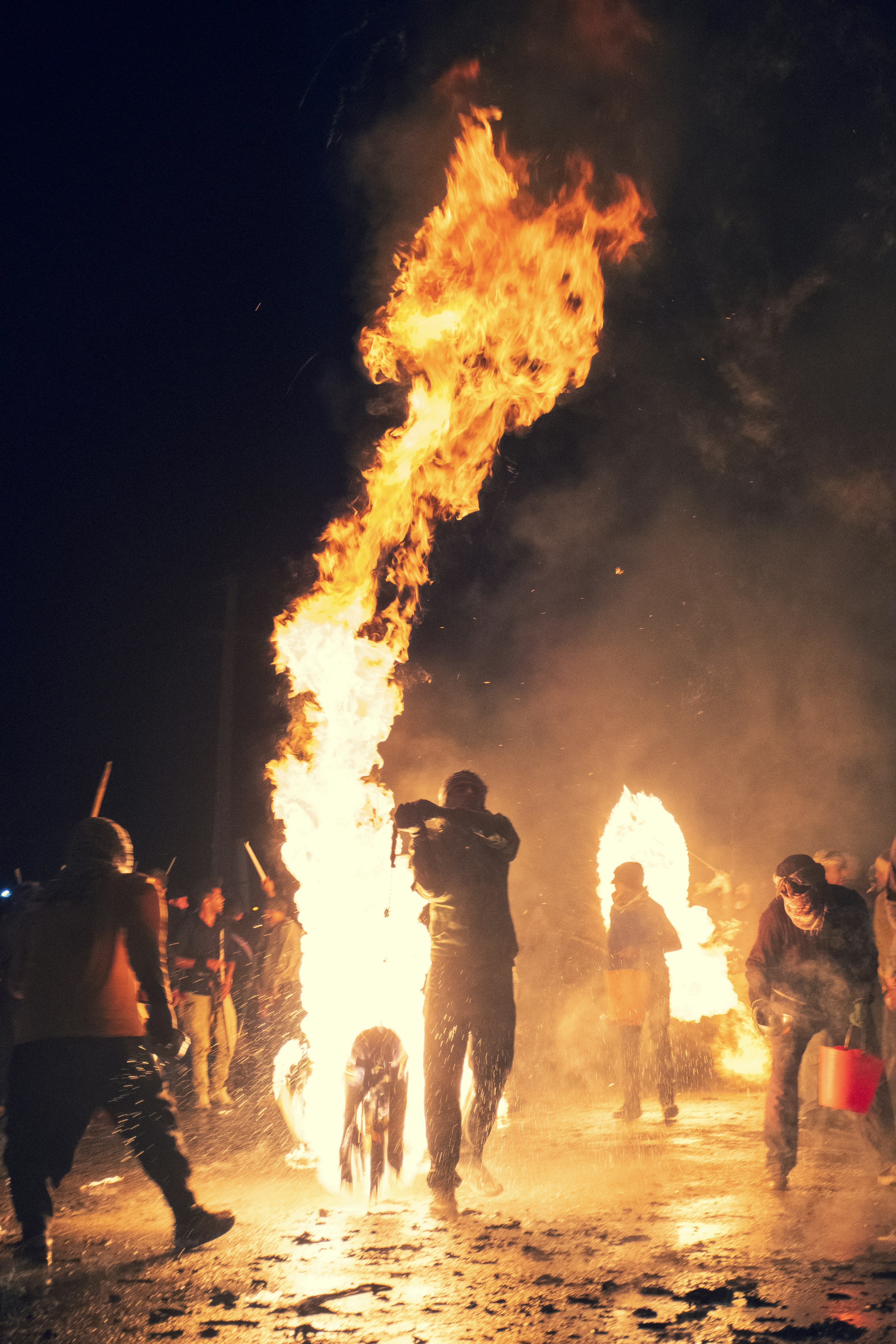 A group of people standing around a fire