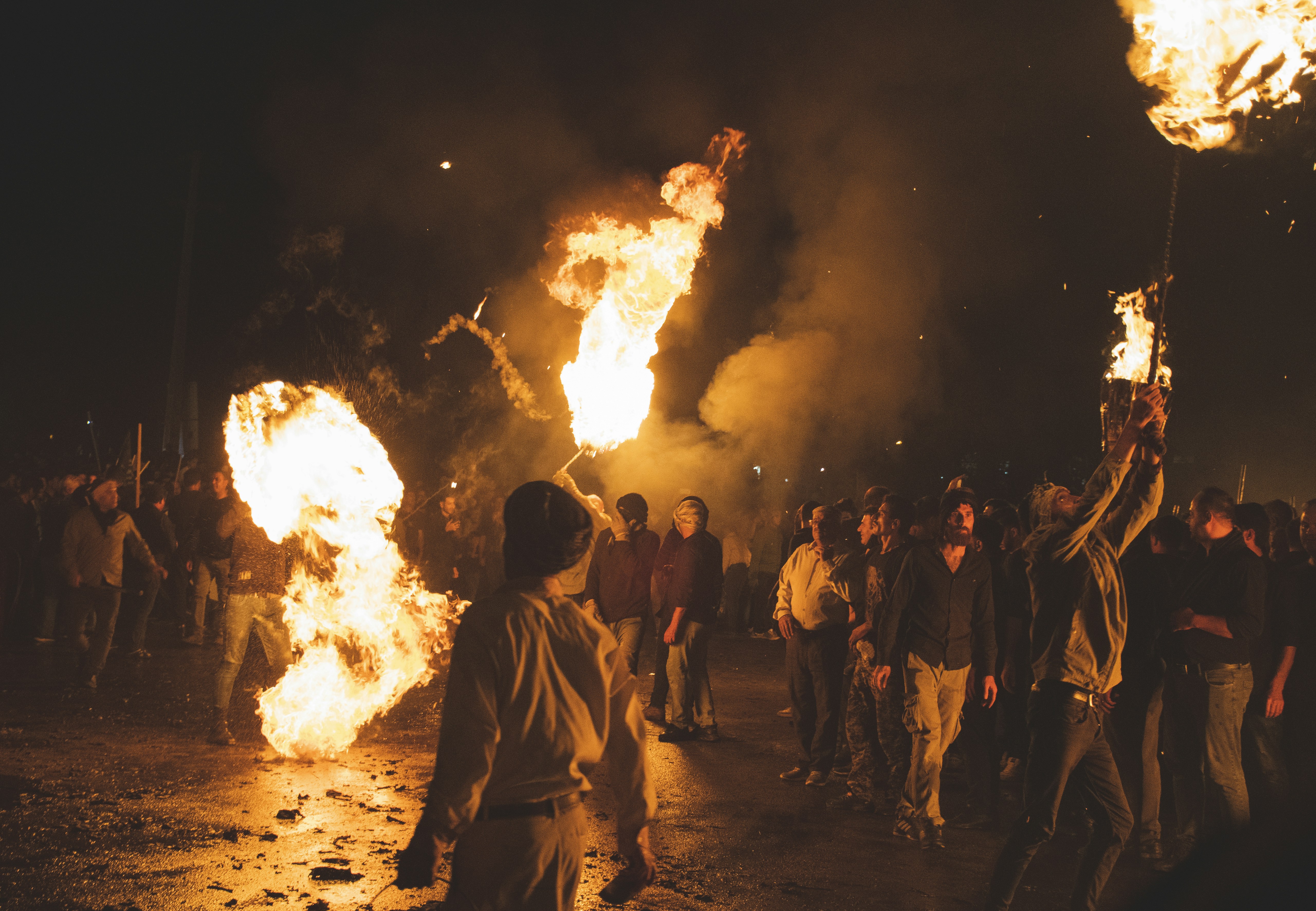 A group of people standing around a fire pit