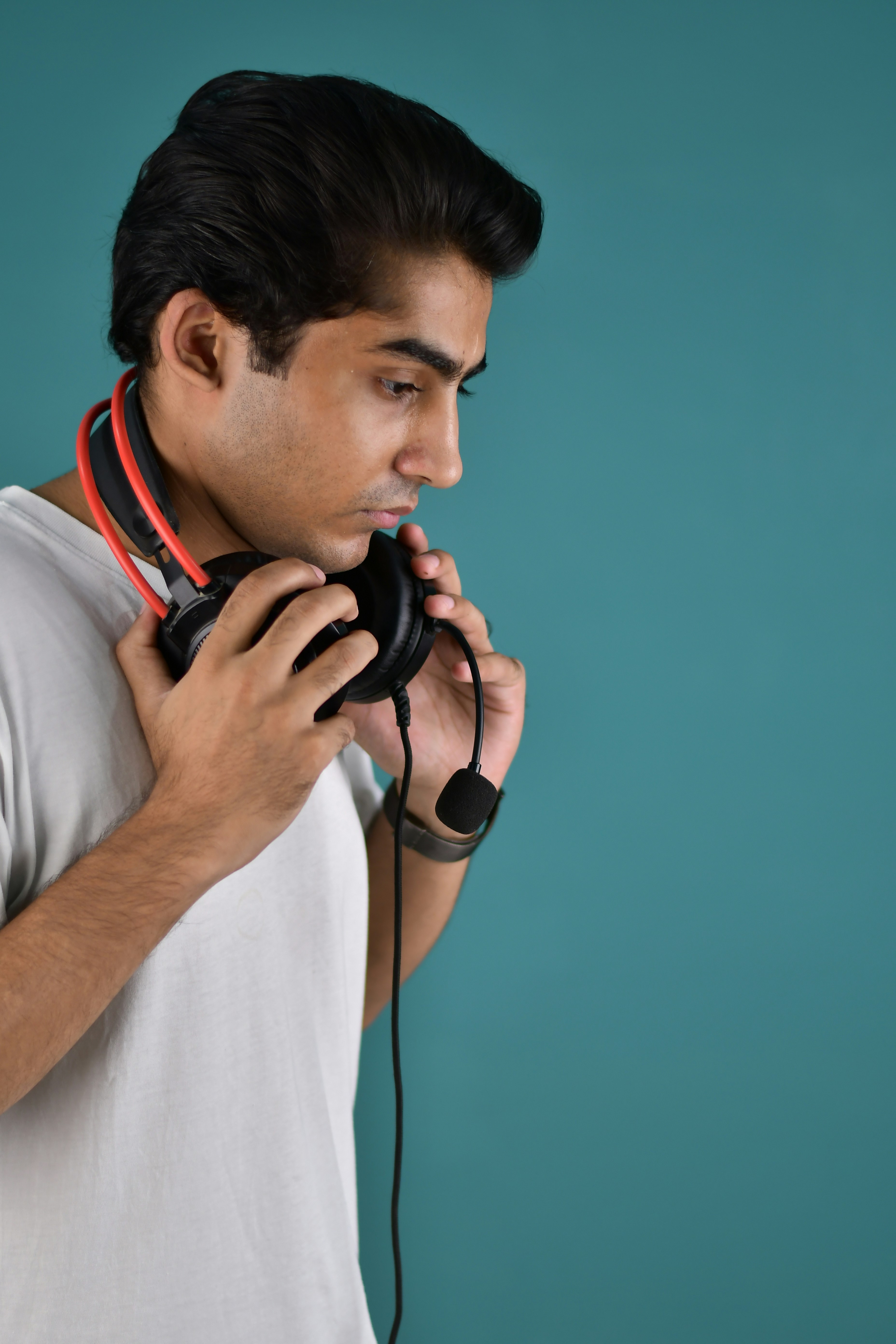 Um homem segurando um par de fones de ouvido no ouvido