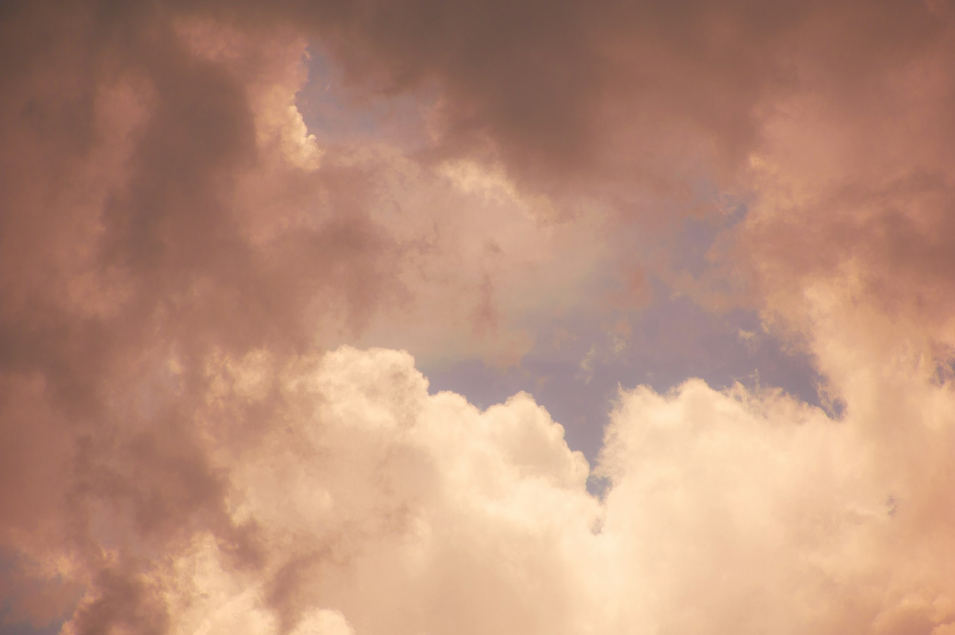 A plane flying through a cloudy blue sky