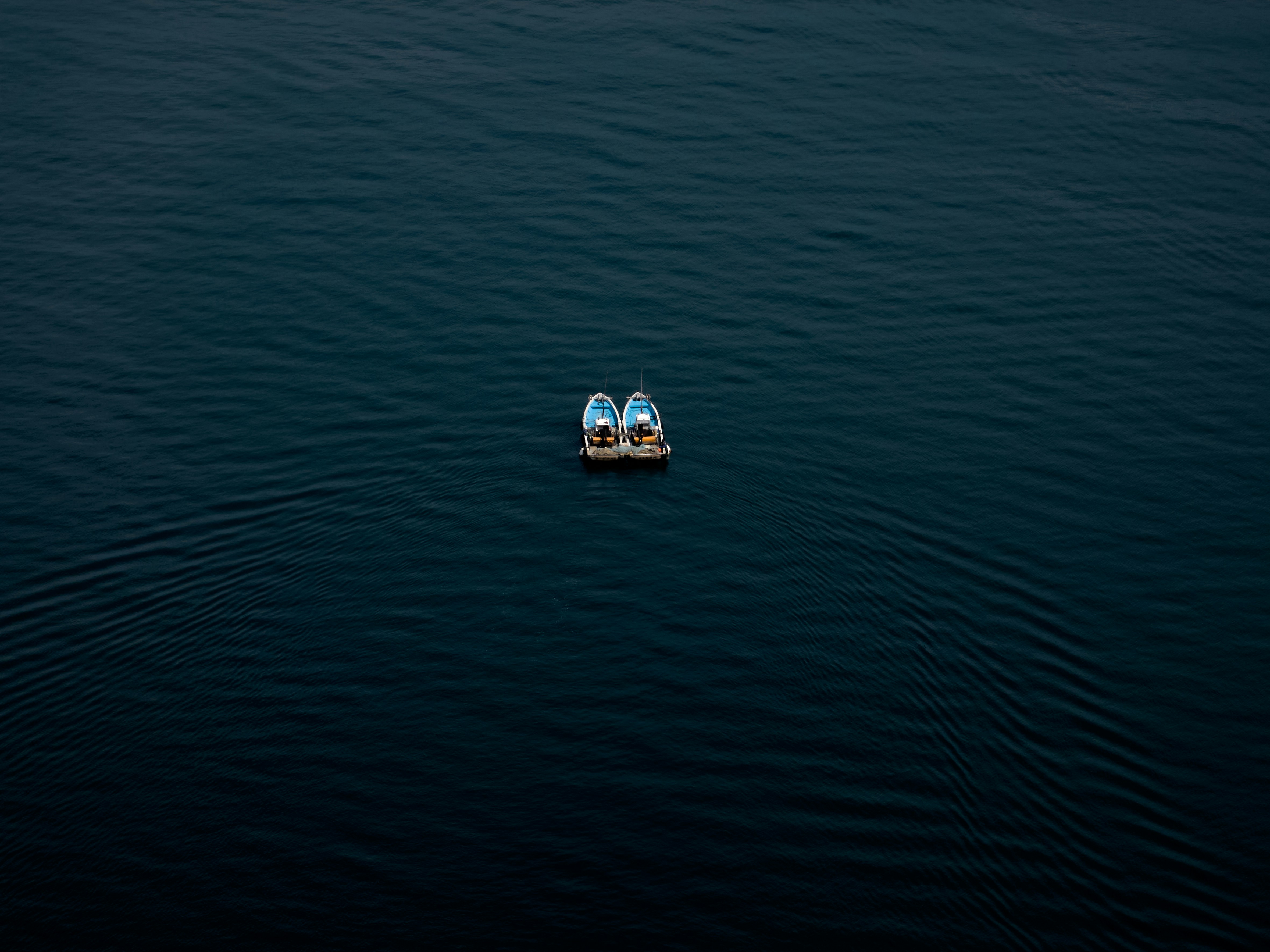 A small boat floating on top of a large body of water photo – Free Sea ...