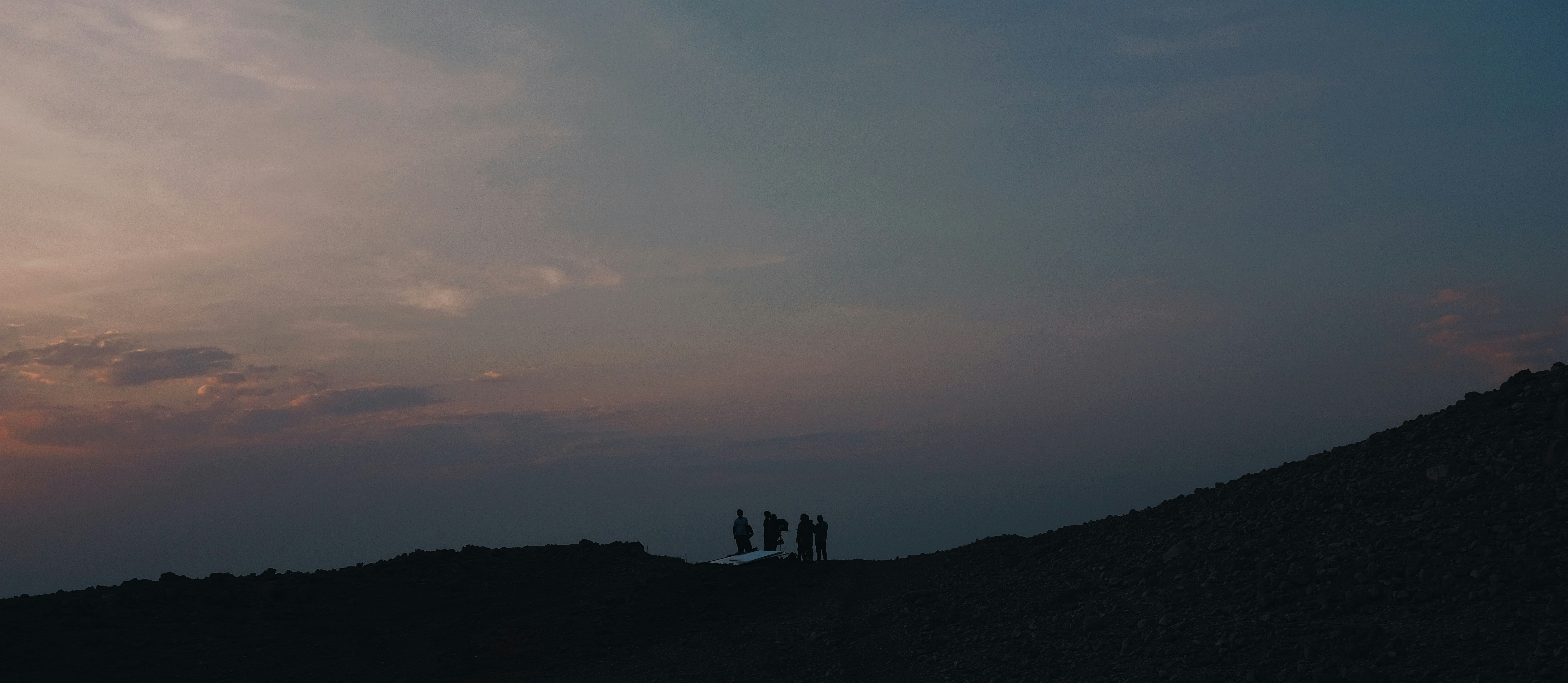 A couple of people standing on top of a hill