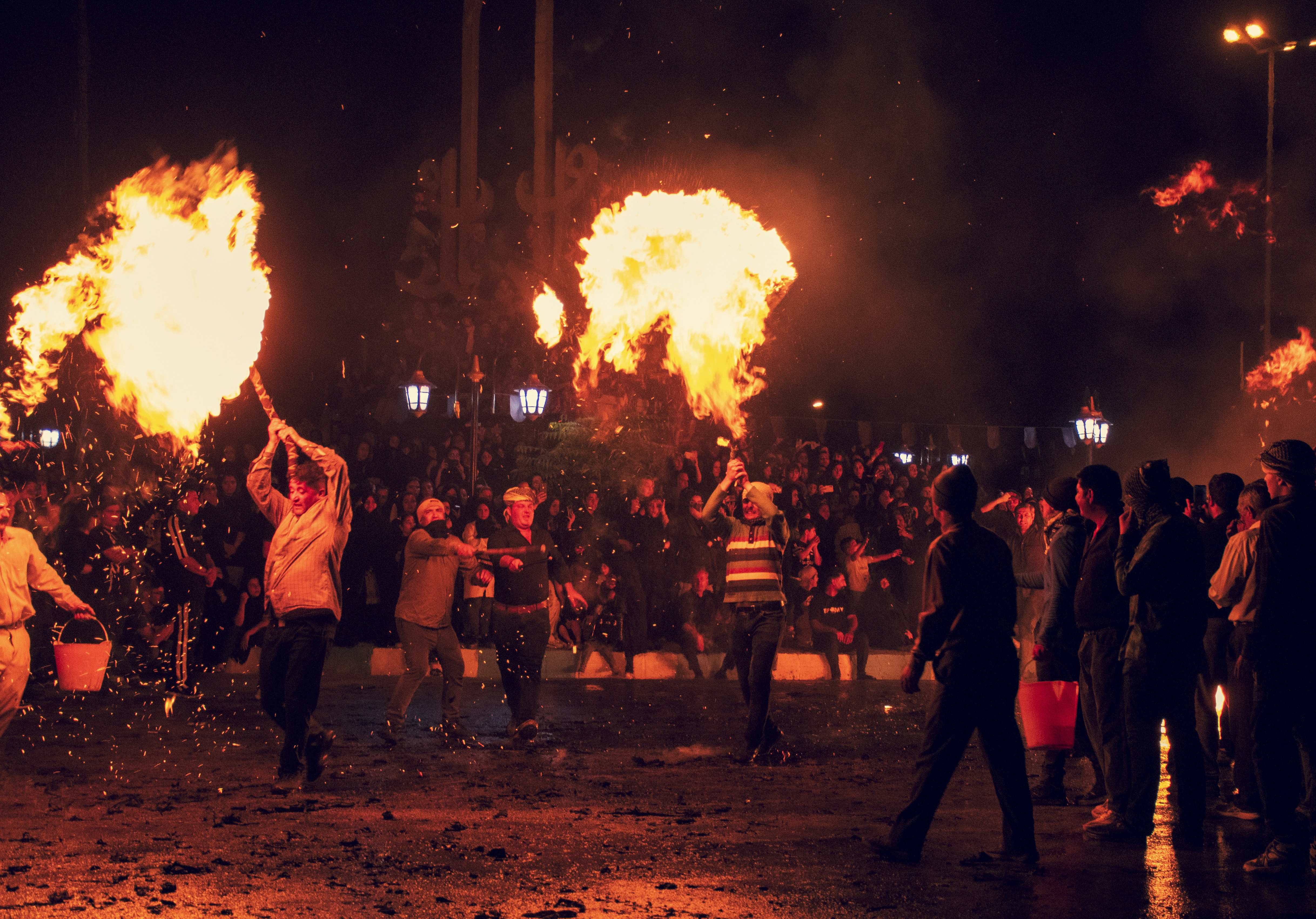 A group of people standing around a fire pit
