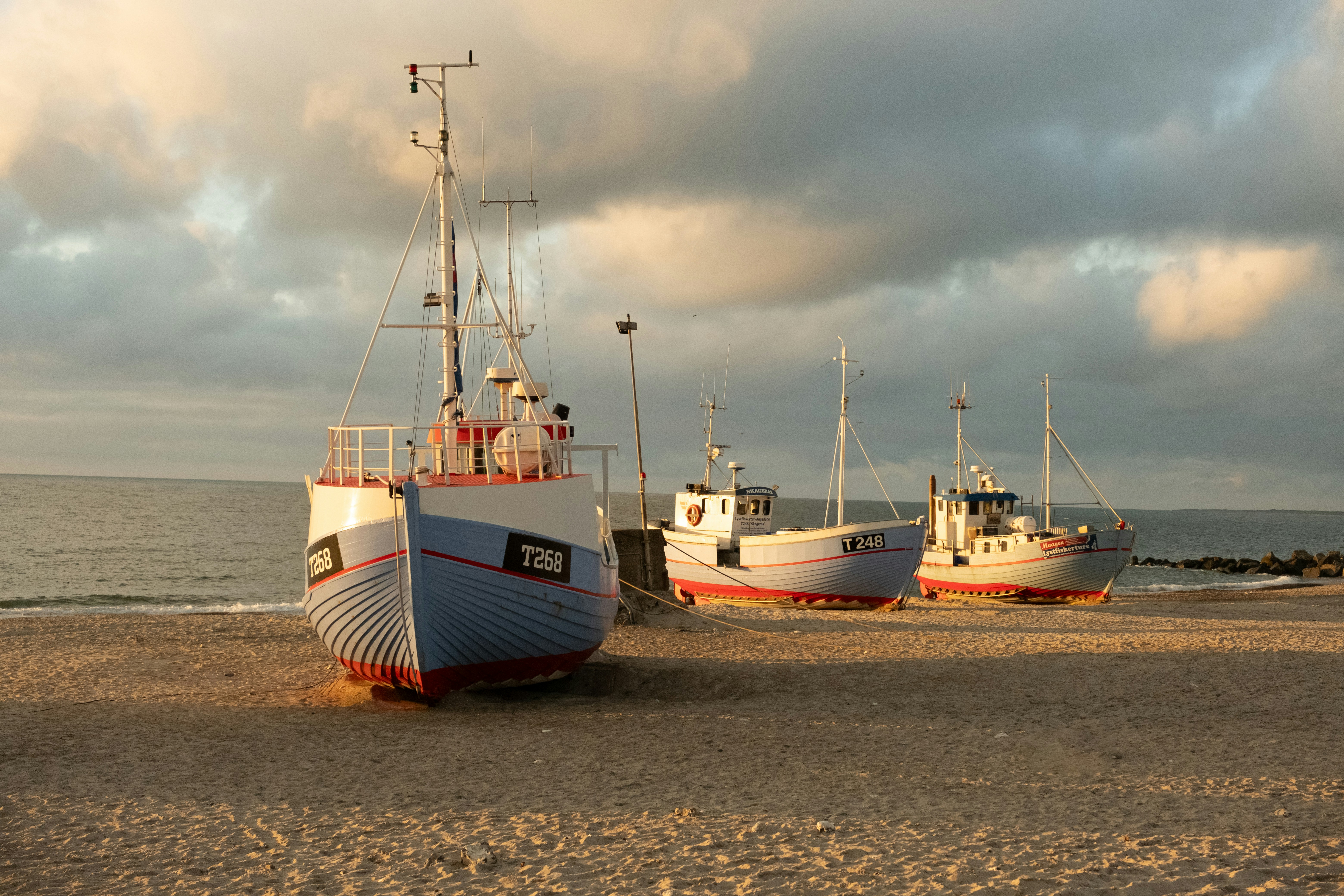 A group of boats sitting on top of a sandy beach