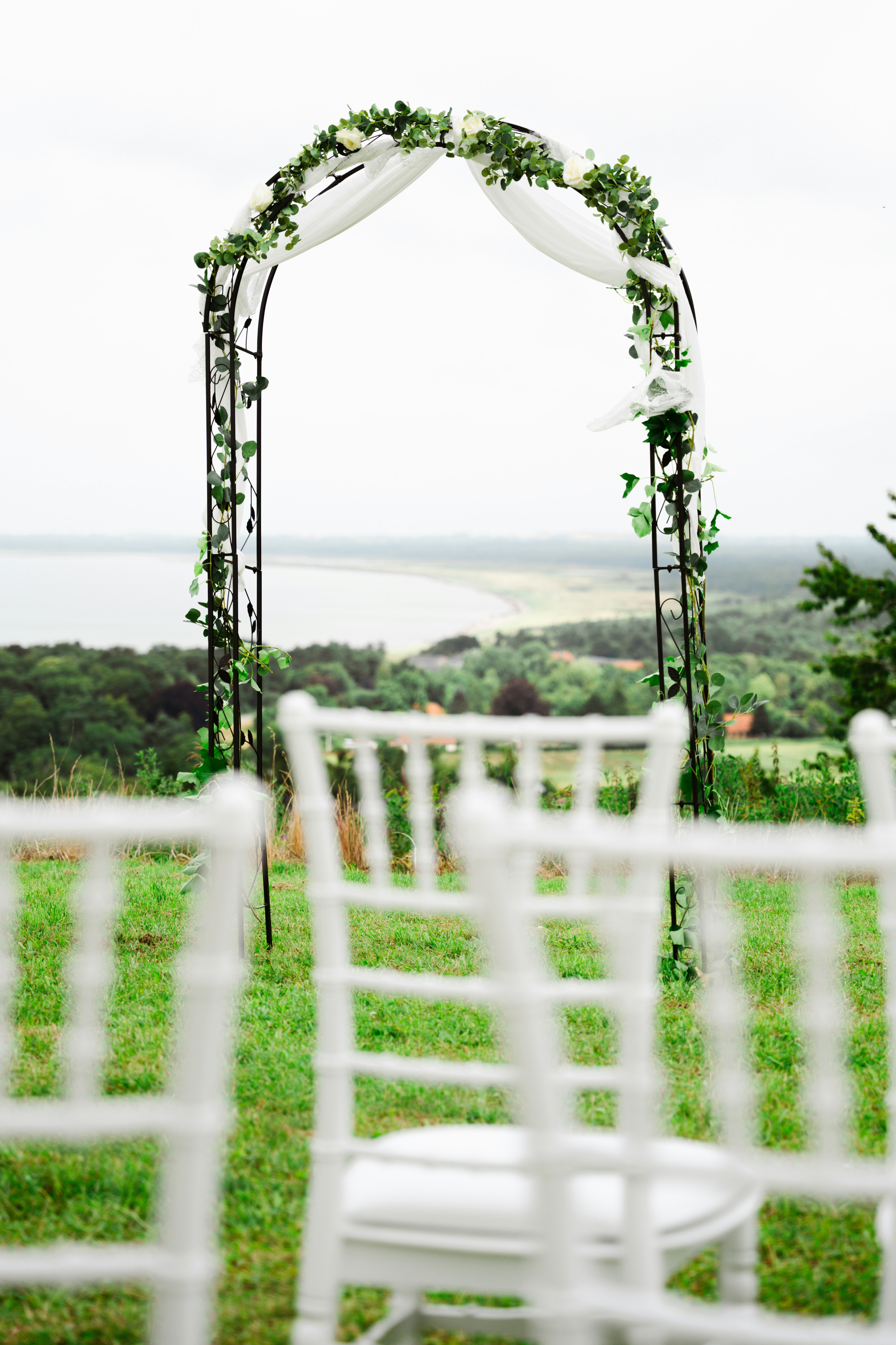 An outdoor ceremony set up with white chairs