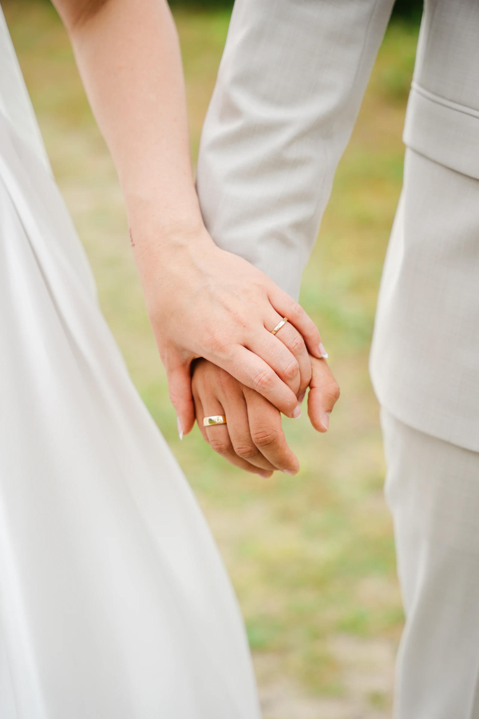 Gros plan sur deux mains qui se tiennent, comparaison entre cohabitation légale et mariage en Belgique
