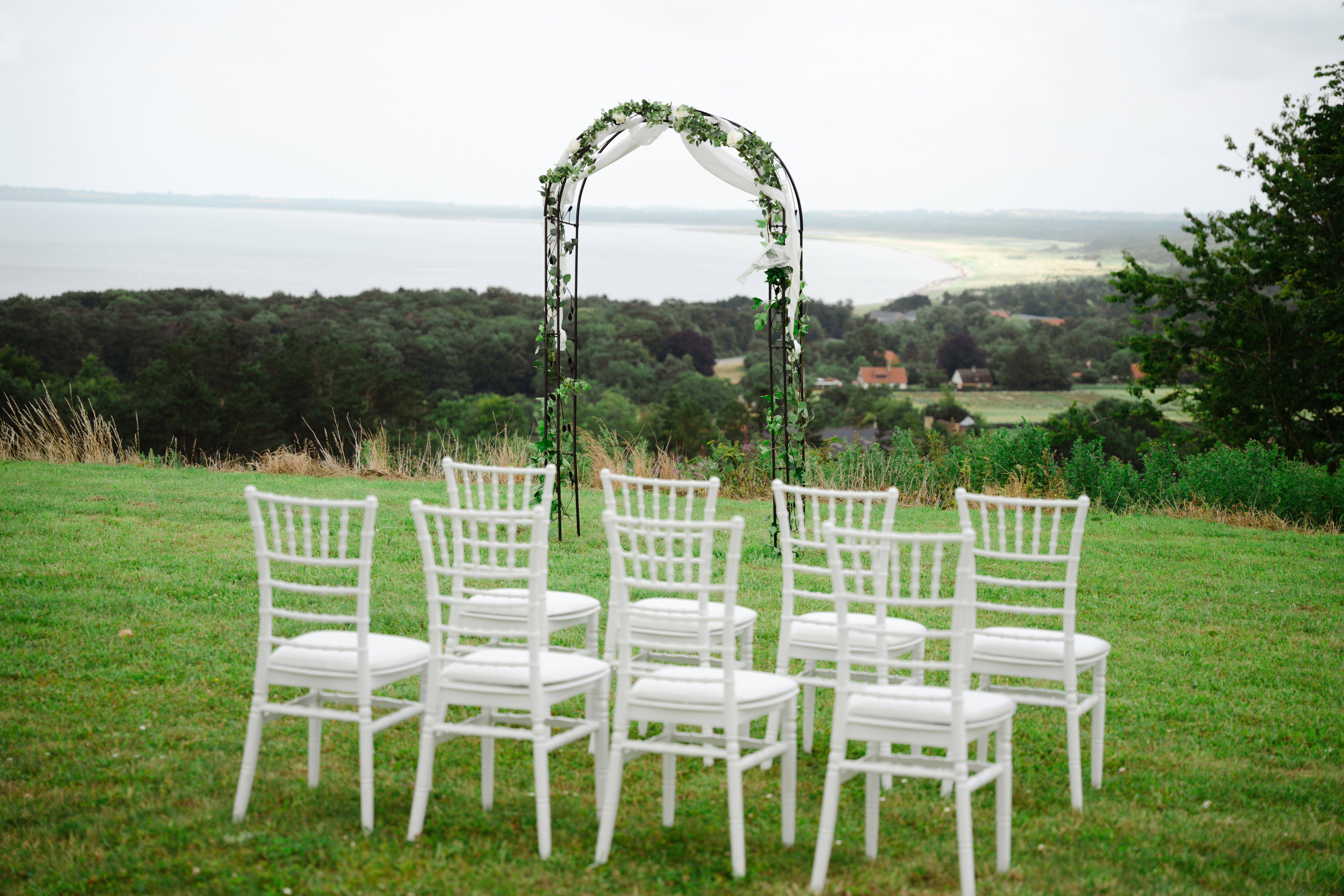 A set of white chairs sitting on top of a lush green field