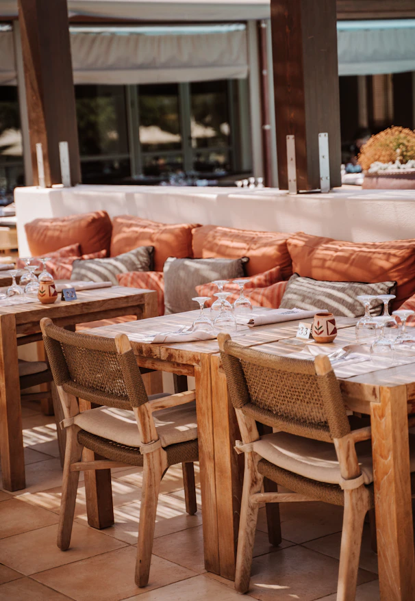 A restaurant with tables and chairs and a table with place settings