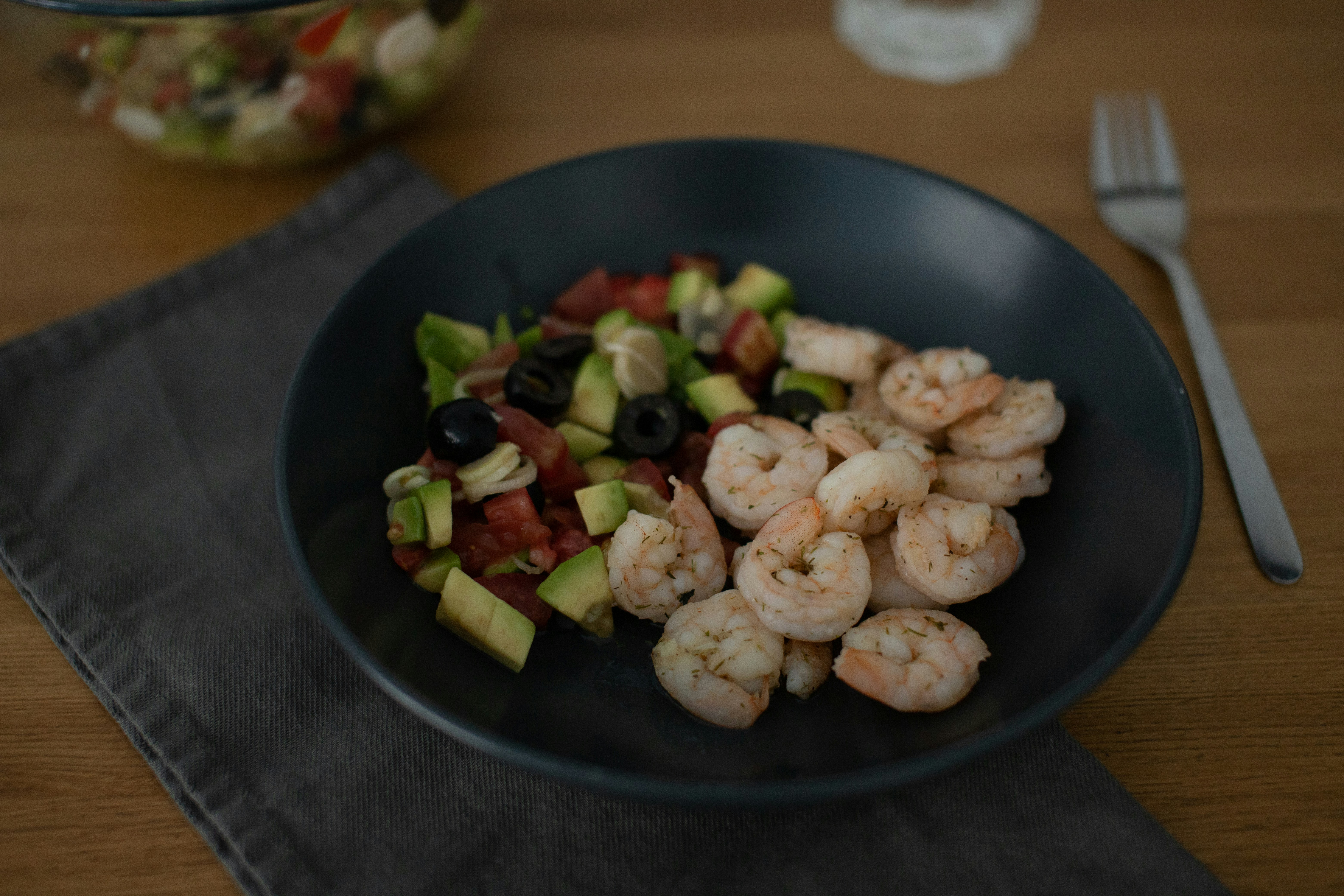 A bowl of shrimp, avocado, and tomato salad