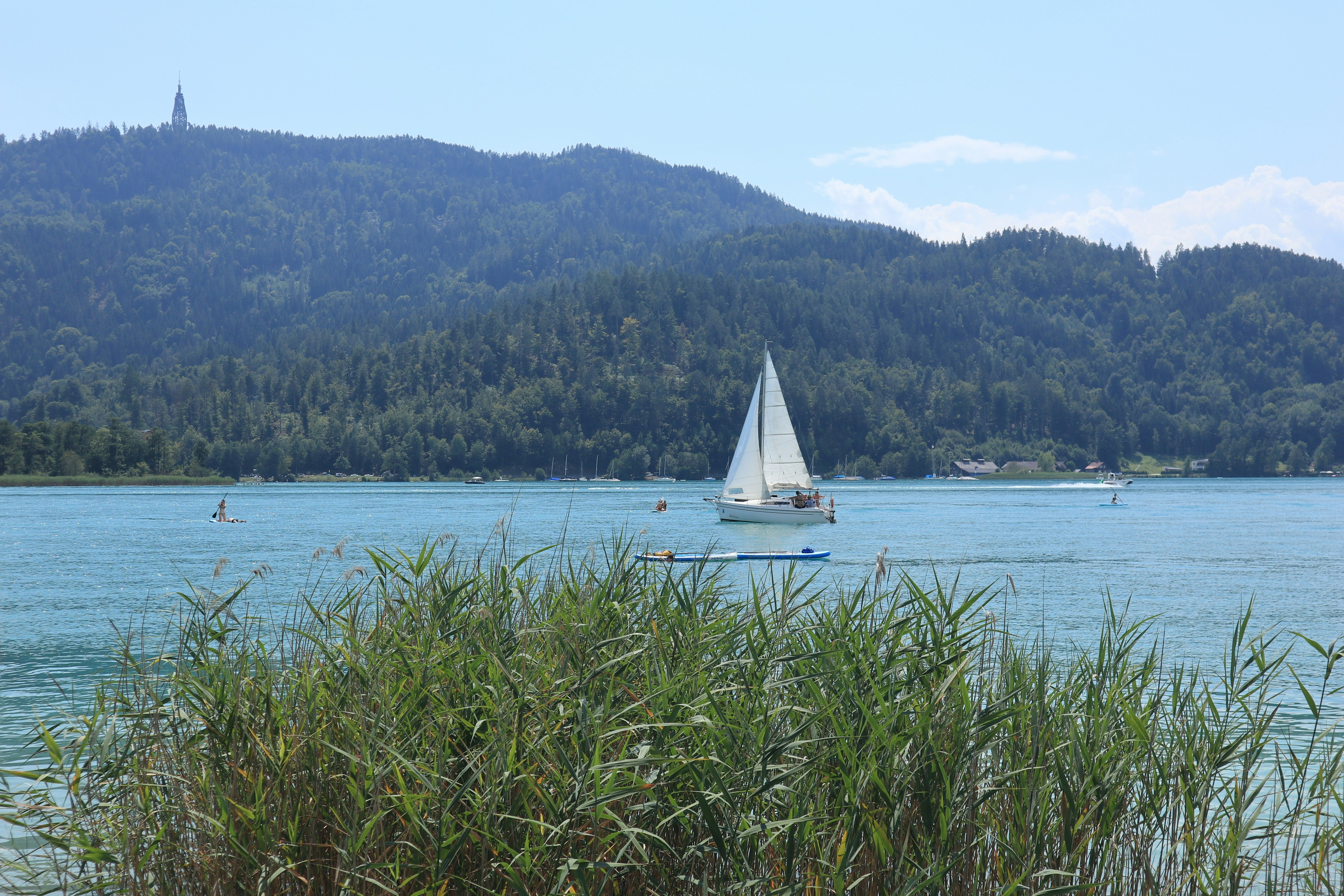 A sailboat on a lake with mountains in the background, 