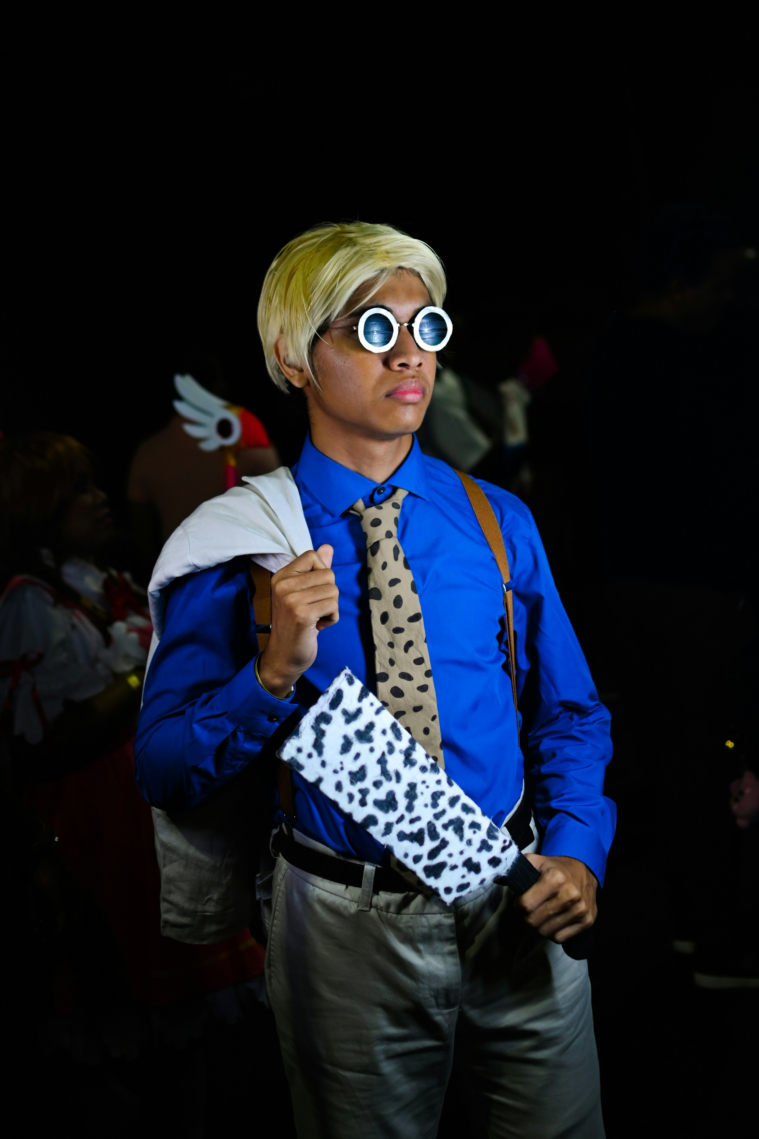 Seorang pria berbaju biru dan dasi memegang kotak putih