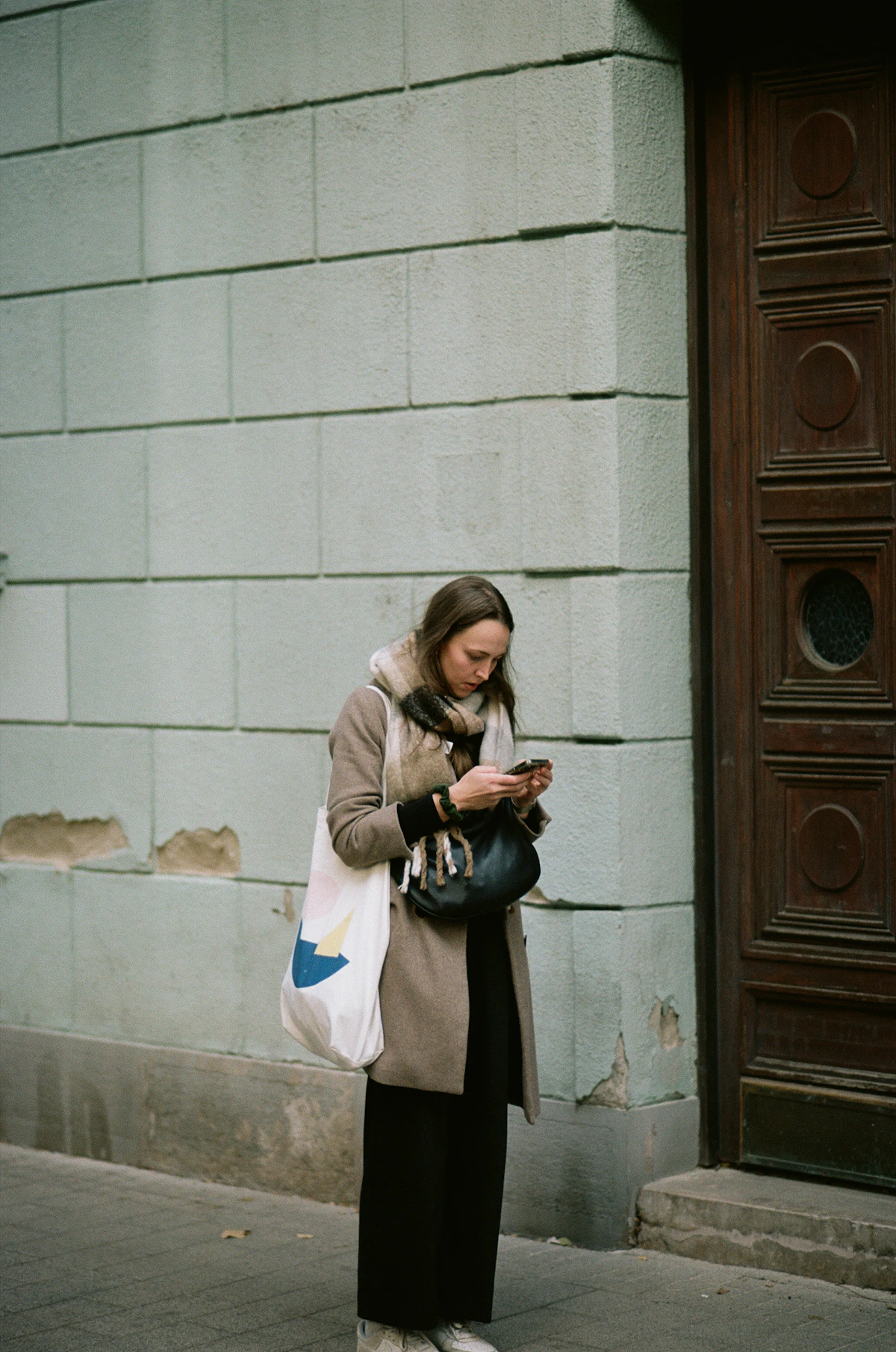 Person walking through a Tokyo residential area while looking at their smartphone