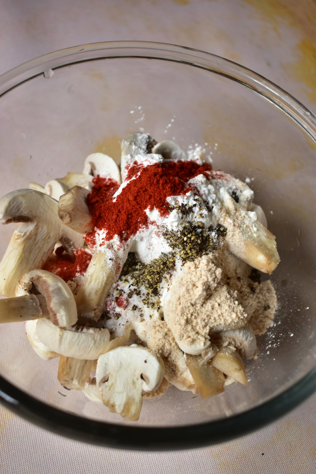 A glass bowl filled with mushrooms and spices