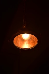A light hanging from a ceiling in a dark room