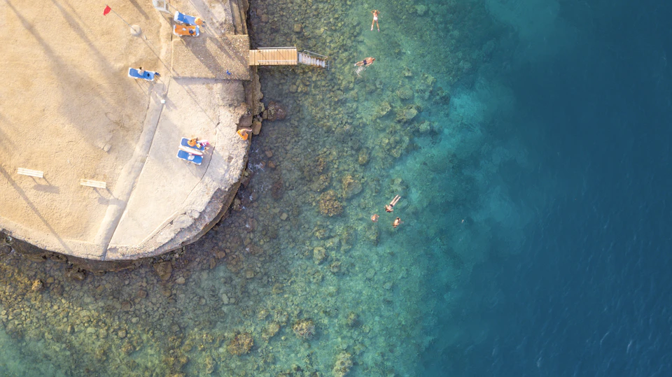 Swimmers over the reef off a beach in Hurghada, seen from a drone.