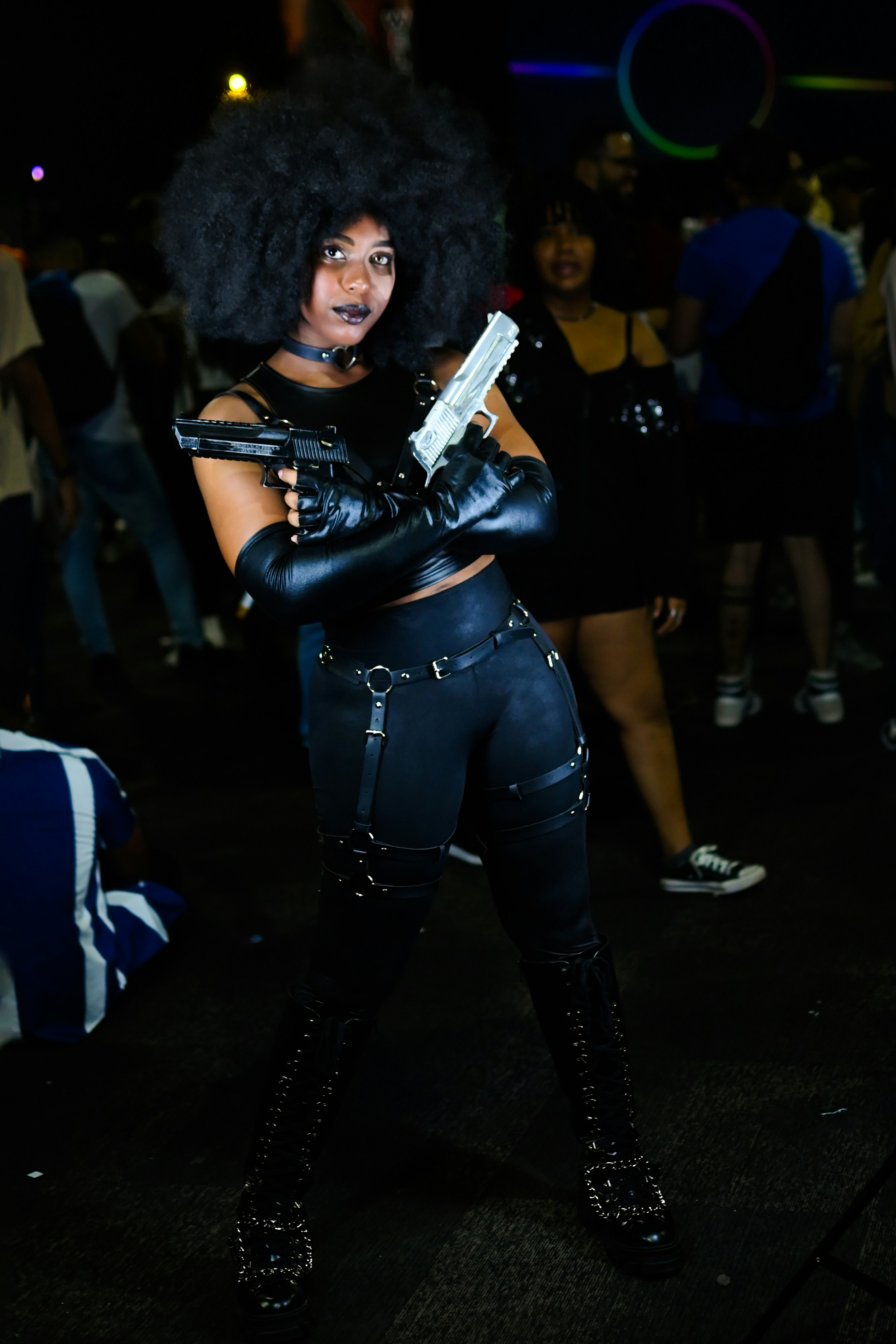 Seorang wanita berpakaian hitam memegang pistol
