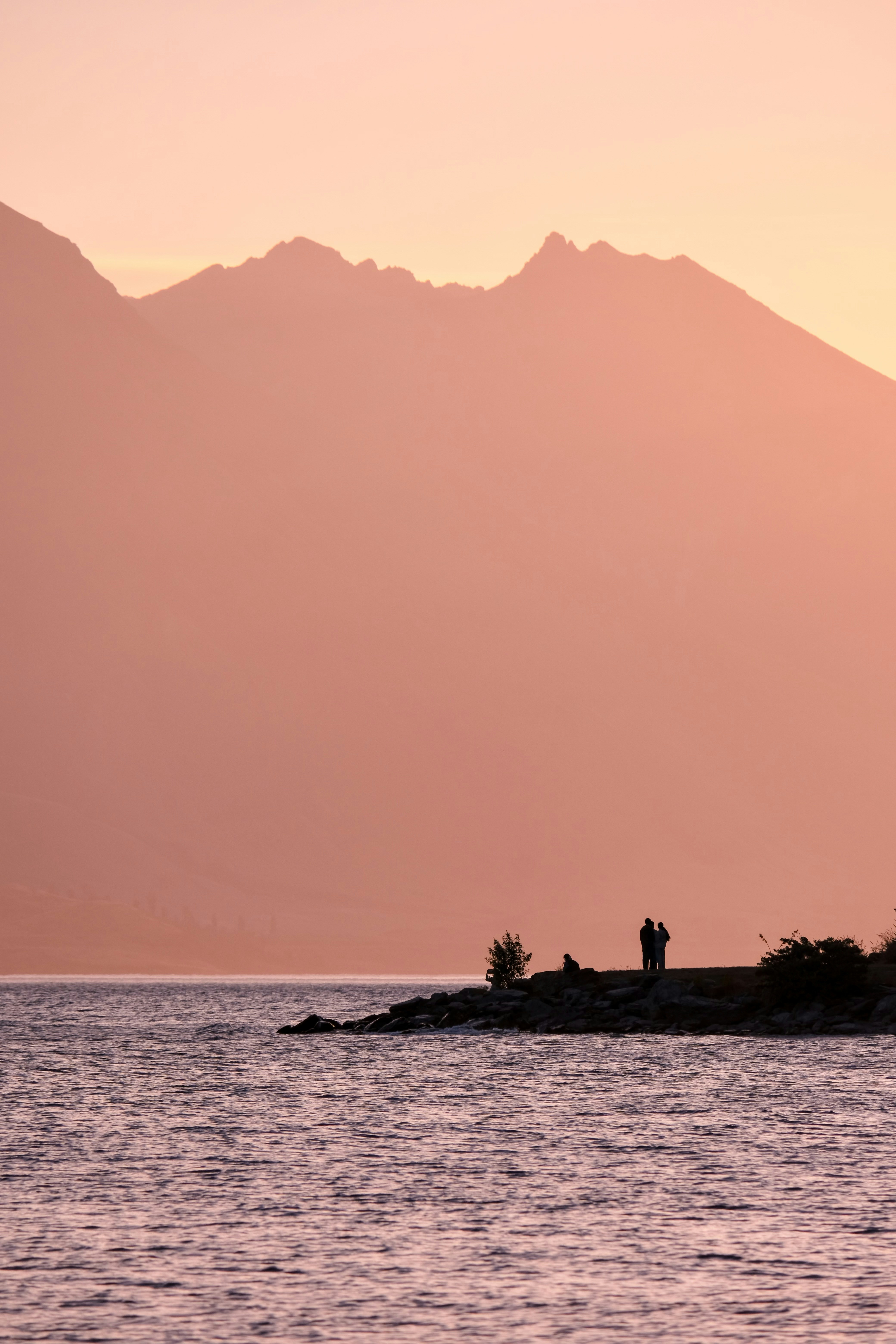 A couple of people standing on top of a small island