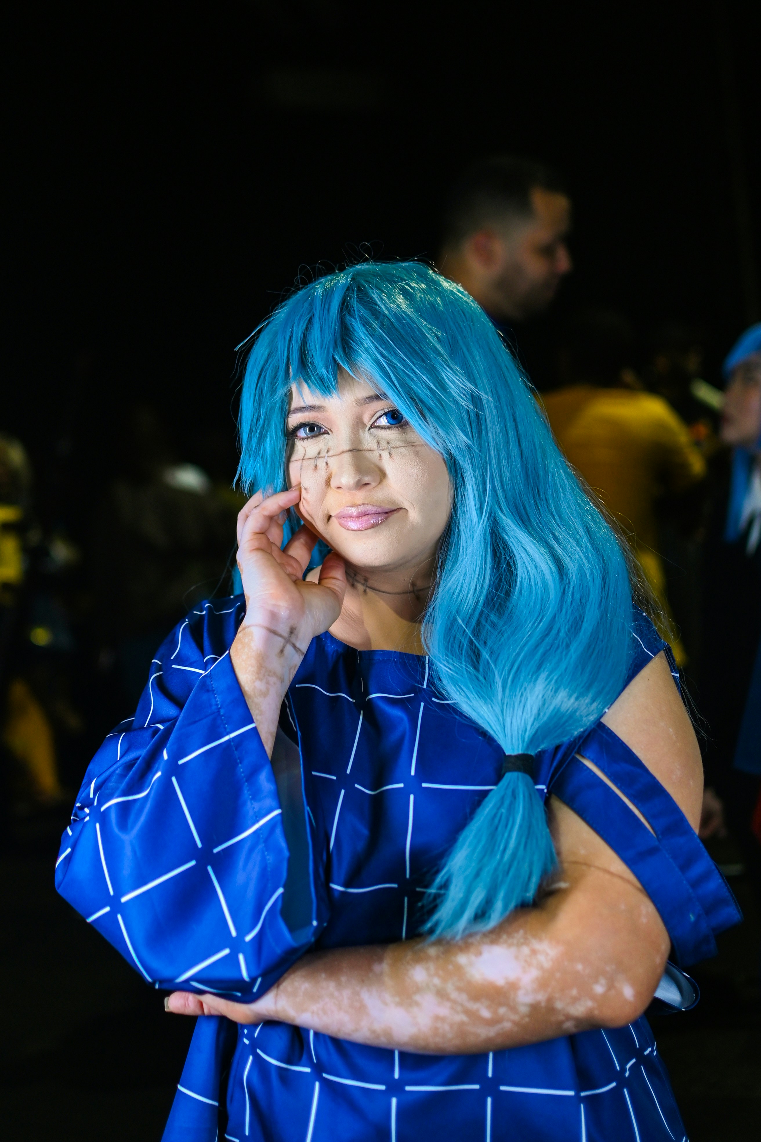 Seorang wanita berambut biru berbicara di ponsel