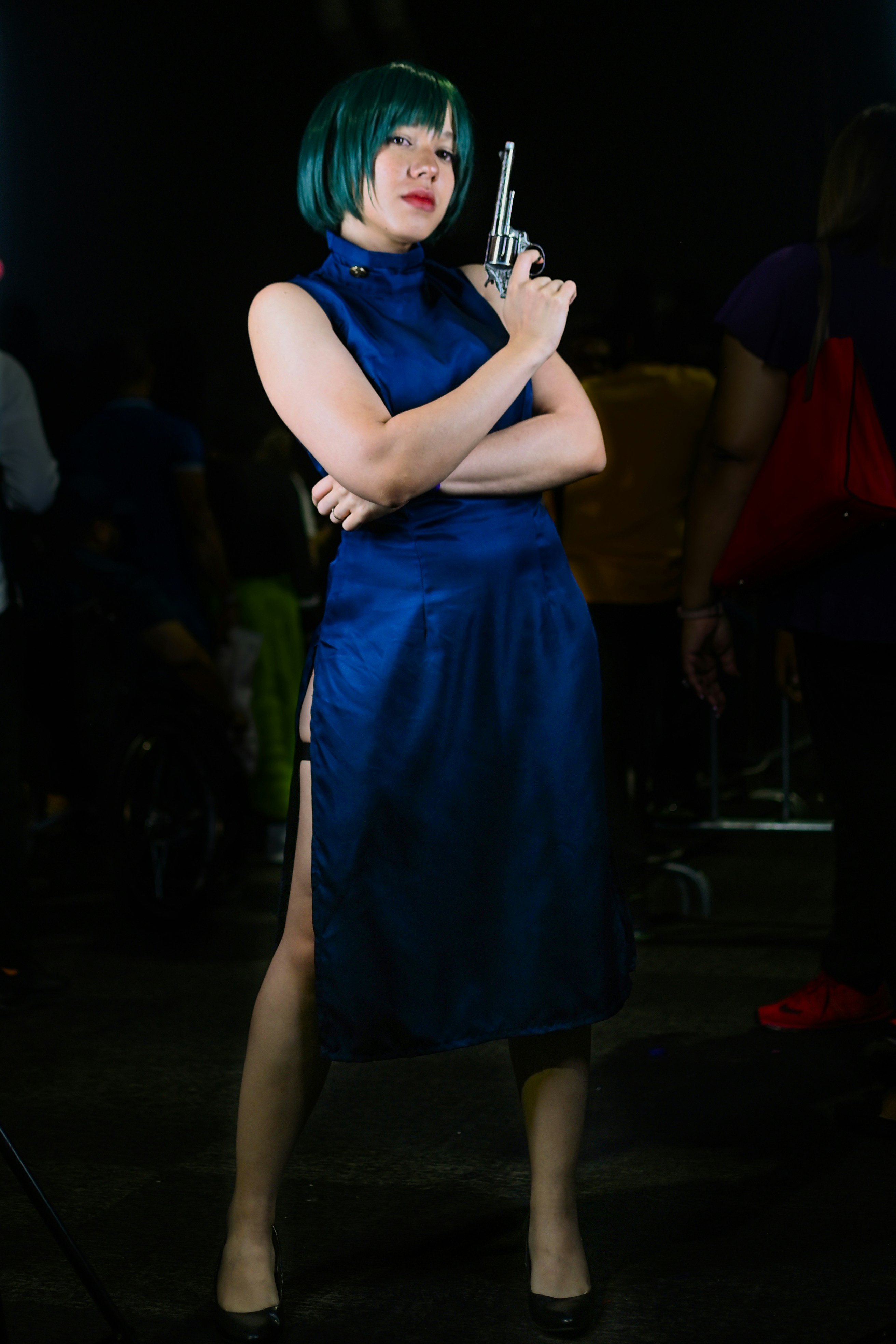 Seorang wanita bergaun biru memegang pistol